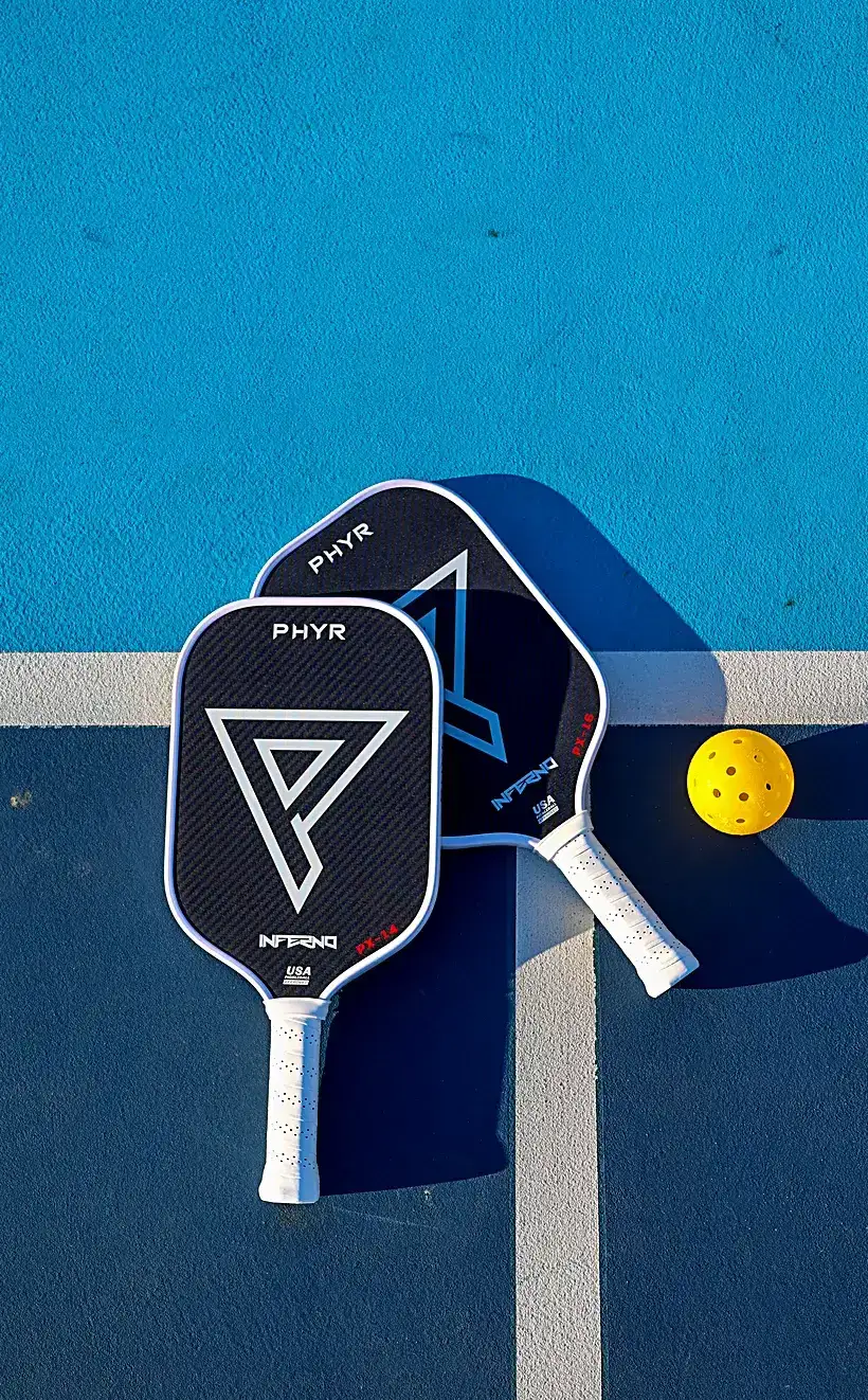 Two Inferno paddles and a ball on court