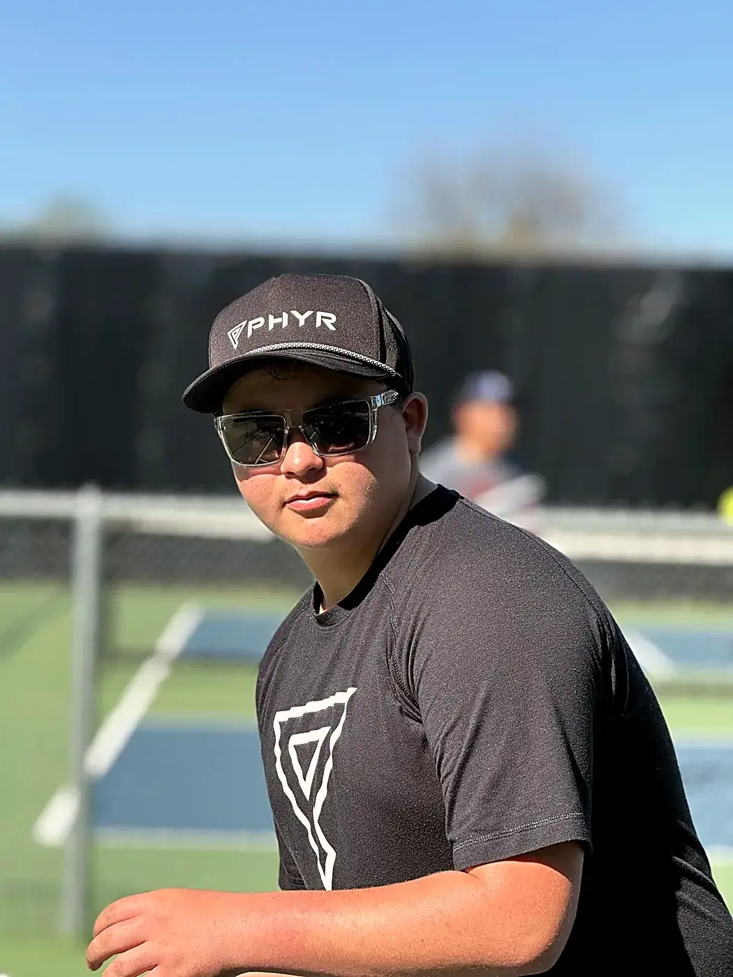 Player in a PHYR cap and tee on court
